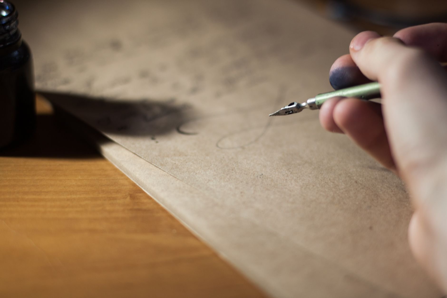 Close-up of a hand writing with a fountain pen on vintage paper, warm editorial light