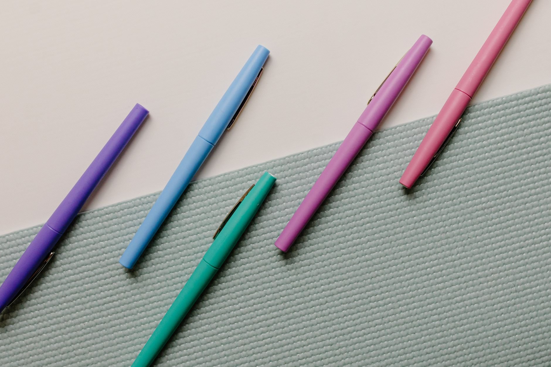 Assorted premium pens arranged artfully on a textured surface
